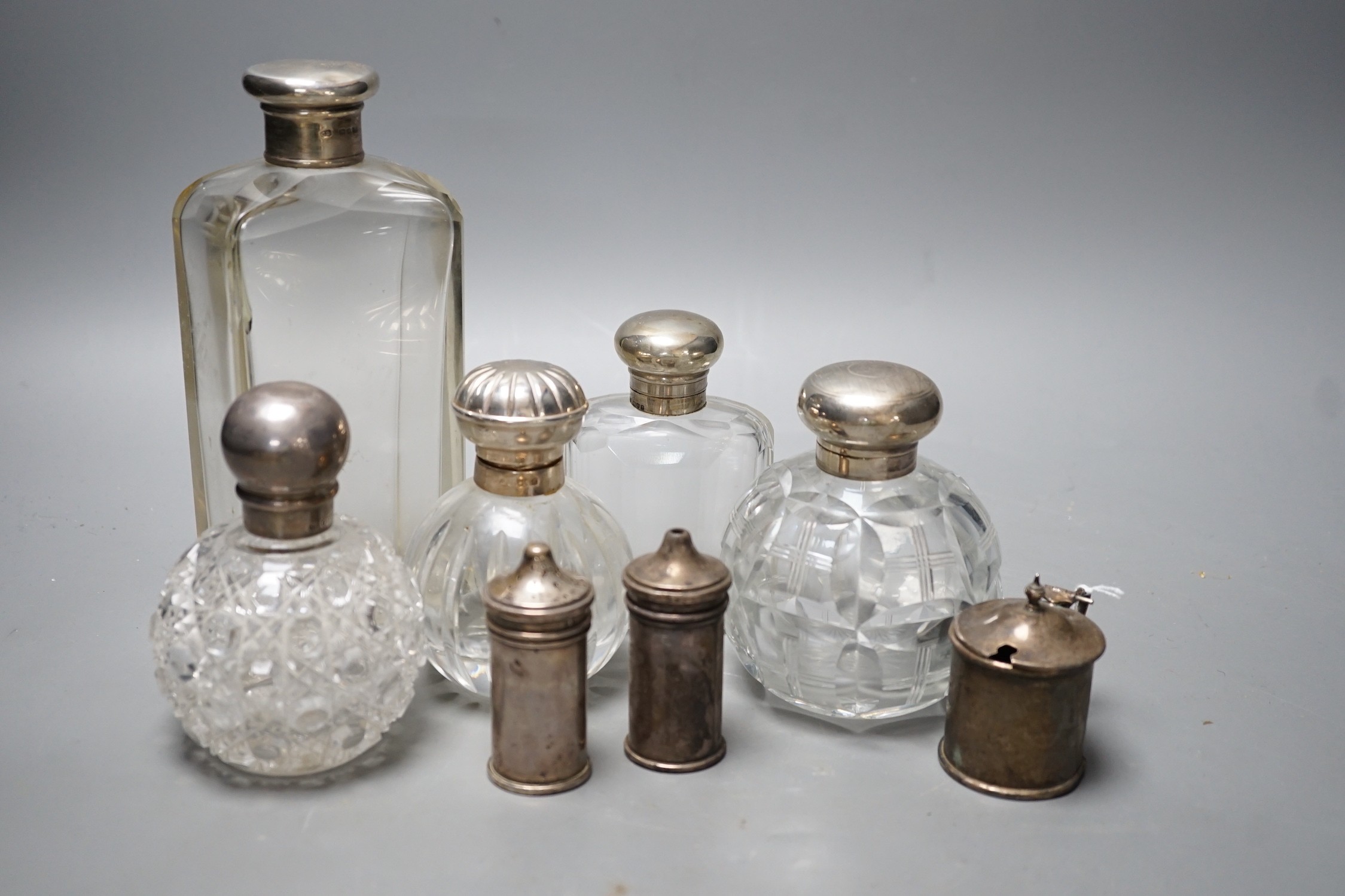Three silver mounted glass scent bottles, a large silver mounted glass toilet bottle and three silver condiments.